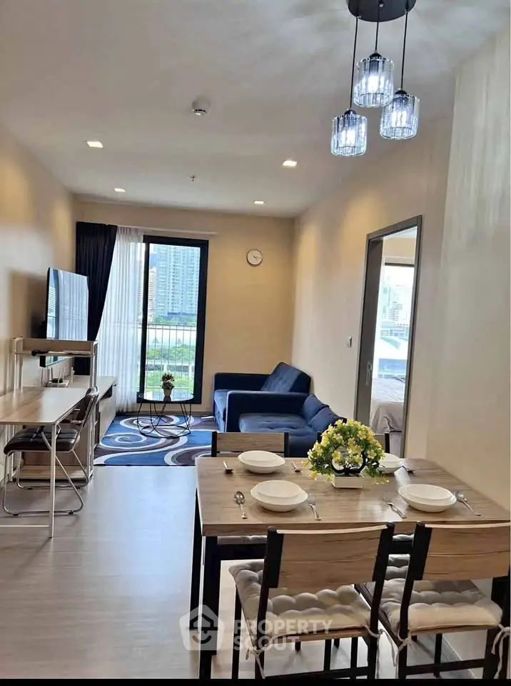 Modern living room with dining area and city view, featuring stylish furniture and elegant lighting.