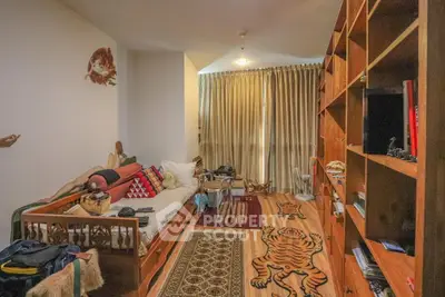 Cozy living room with wooden shelves and unique decor, perfect for relaxation and reading.