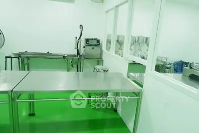 Modern industrial kitchen with stainless steel tables and green flooring