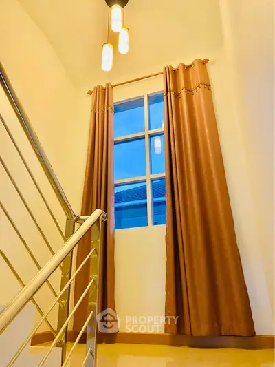 Elegant staircase with modern railing and window view in a stylish home interior