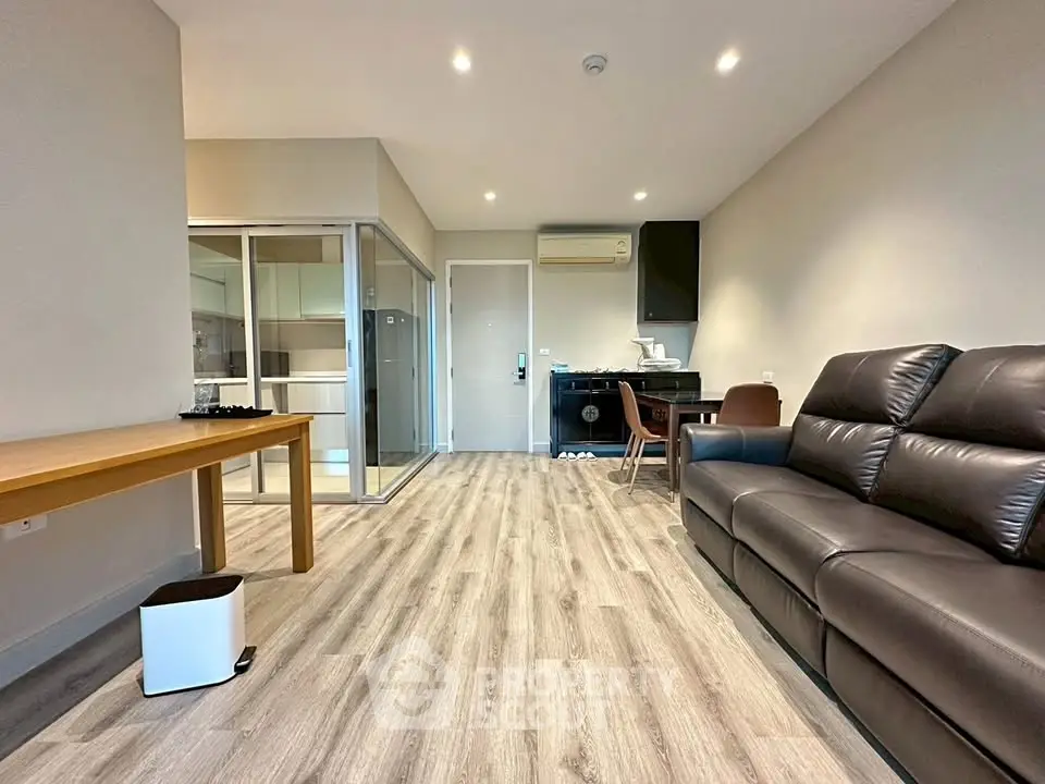 Modern living room with sleek furniture and open layout, featuring a stylish sofa and wooden flooring.