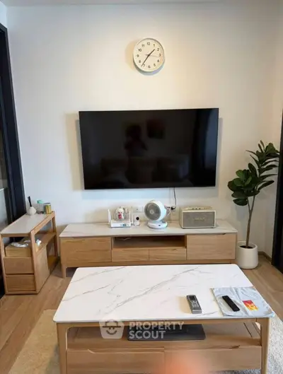 Modern living room with sleek TV setup and stylish wooden furniture, perfect for contemporary living.