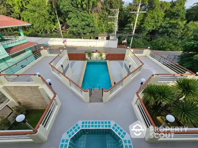 Stunning aerial view of a luxurious pool area with lush greenery and modern design.