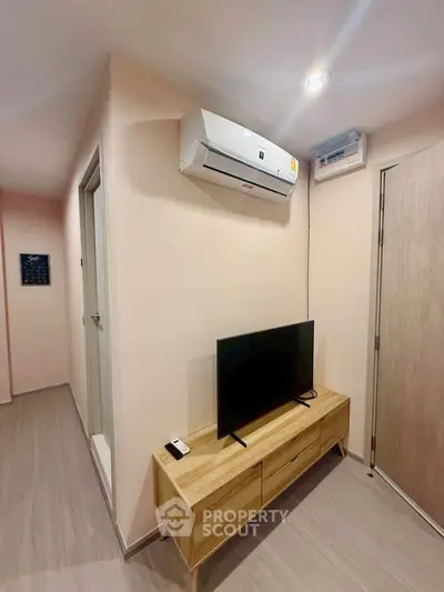 Modern living room with sleek air conditioning and stylish TV stand in a cozy apartment.