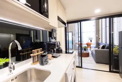 Modern kitchen with sleek appliances and open view to stylish living room