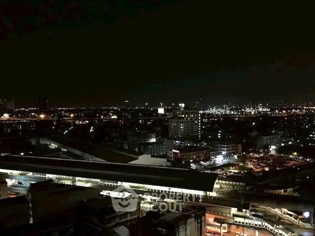 Stunning nighttime cityscape view from a high-rise building, showcasing vibrant urban lights.