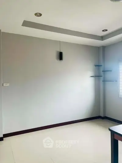 Spacious unfurnished room with modern ceiling design and natural light