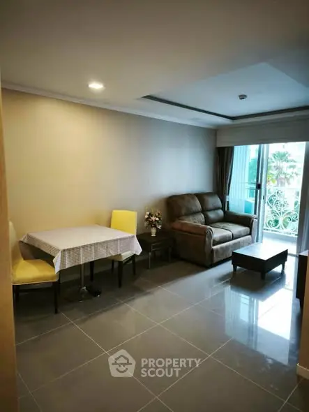 Cozy living room with modern furniture and balcony access in a stylish apartment.