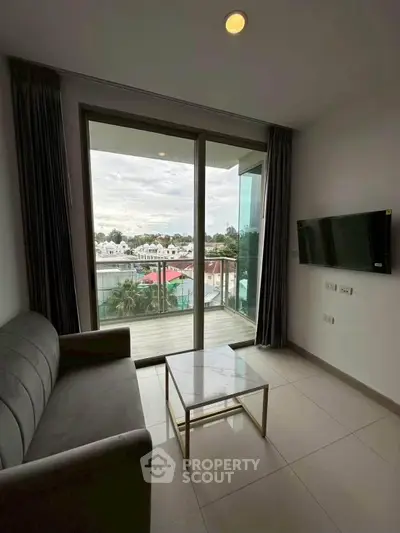 Modern living room with balcony view, sleek sofa, and wall-mounted TV in a stylish apartment.