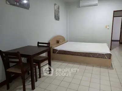 Cozy bedroom with minimalist furniture and tiled flooring, perfect for a comfortable living space.