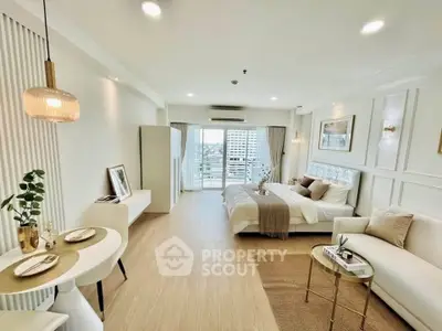 Luxurious open-plan studio with elegant decor and city view balcony, perfect for modern living.