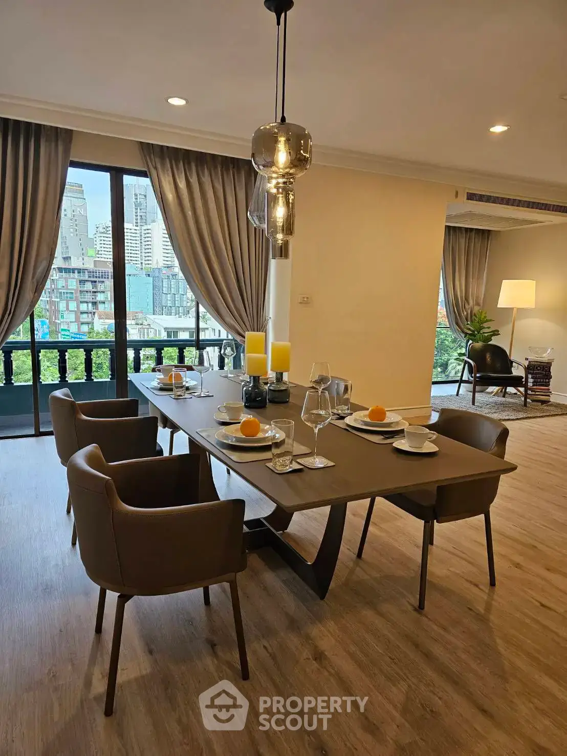 Elegant dining area with city view, featuring modern furniture and stylish decor in a spacious living room.