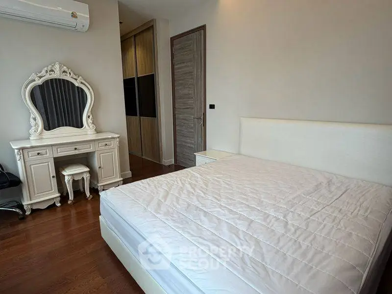 Elegant bedroom with classic vanity and spacious wardrobe in modern apartment