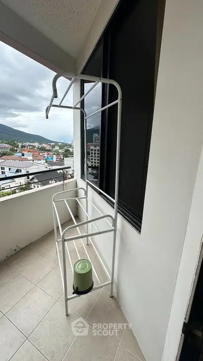 Spacious balcony with city view and drying rack, perfect for urban living.