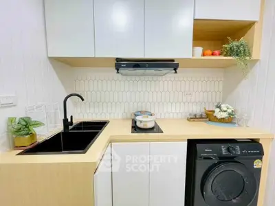 Modern kitchen with sleek cabinetry and integrated appliances in compact layout.