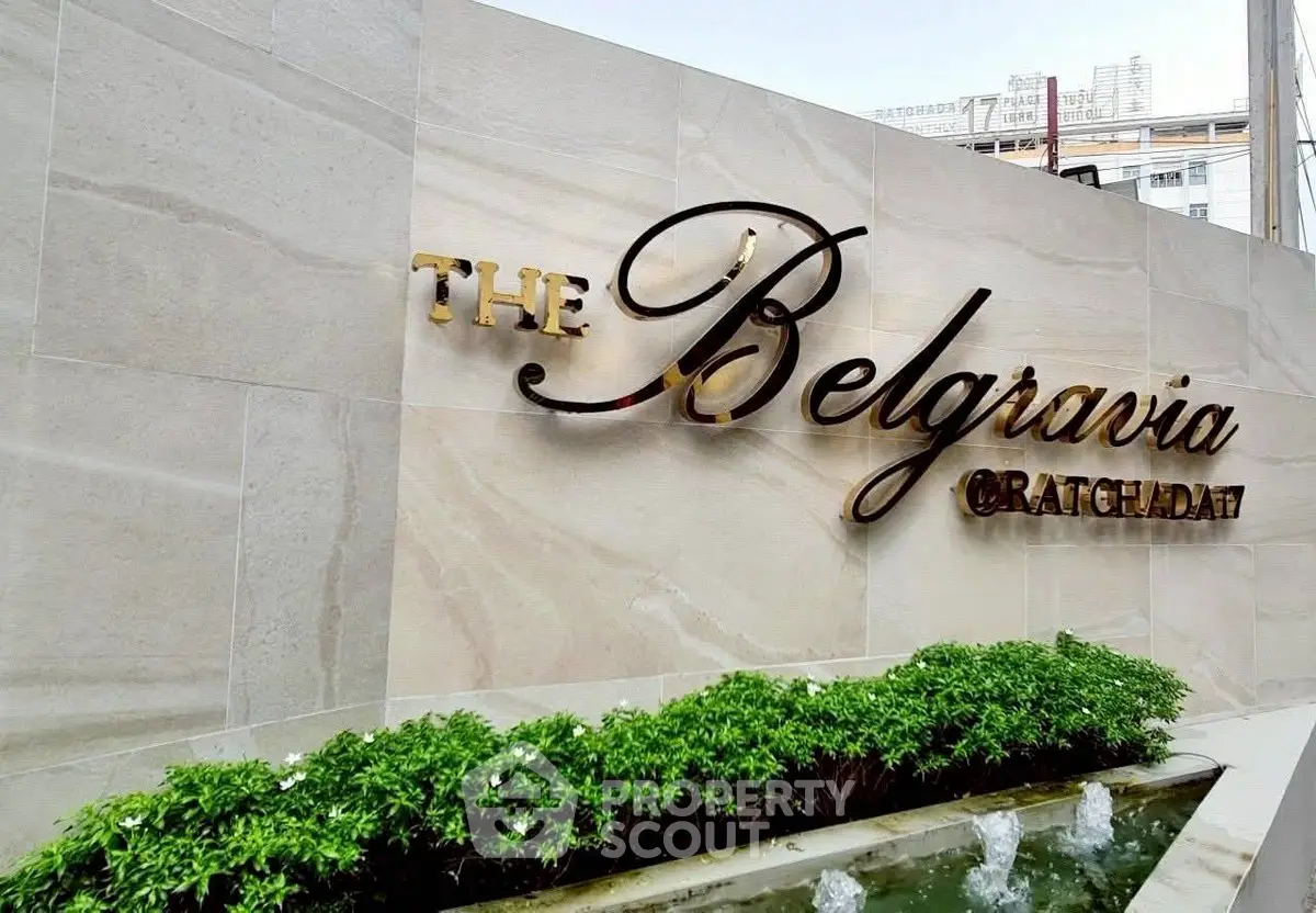 Elegant entrance sign of The Belgravia Ratchada 19 with lush greenery and modern design.