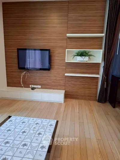 Modern living room with wooden panel wall and built-in TV, featuring elegant decor.