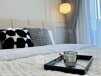 Luxurious bedroom with elegant decor and cozy bedding, featuring a stylish lamp and plush pillows.