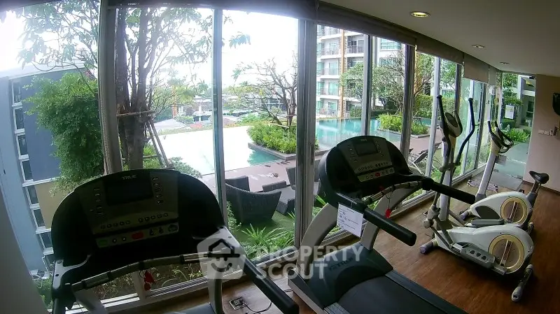 Modern gym with pool view in luxury apartment complex