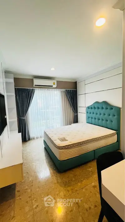 Spacious bedroom with modern decor and large window for natural light