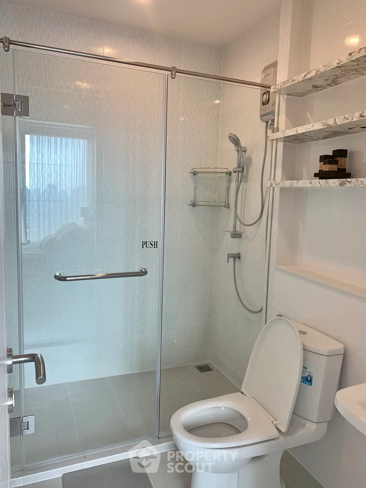 Modern bathroom with glass shower enclosure and sleek fixtures in a contemporary home.