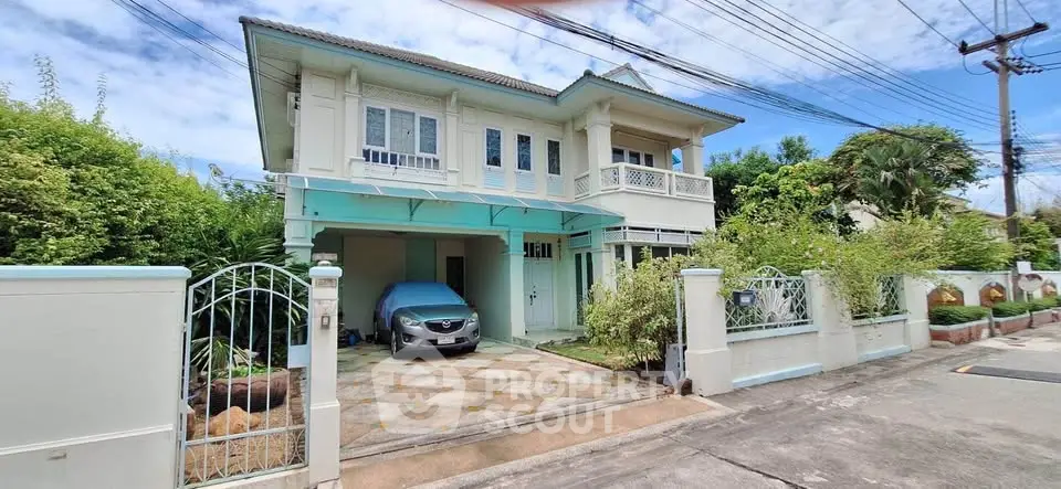 Charming two-story house with carport and lush greenery in a serene neighborhood.