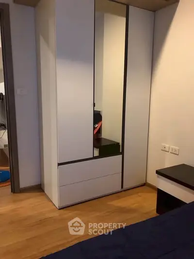 Modern bedroom with sleek wardrobe and wooden flooring
