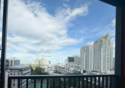 Stunning cityscape view from a high-rise balcony with modern skyscrapers and blue sky.