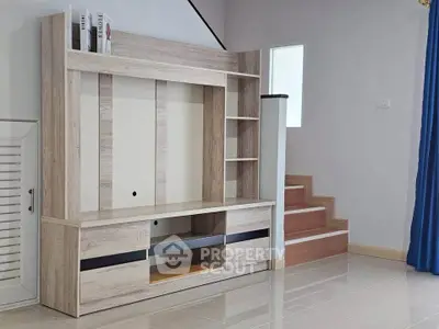 Modern interior with stylish wooden TV cabinet and staircase in a bright living space.