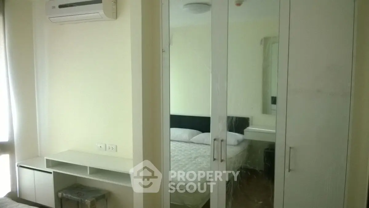 Modern bedroom with mirrored wardrobe and air conditioning unit