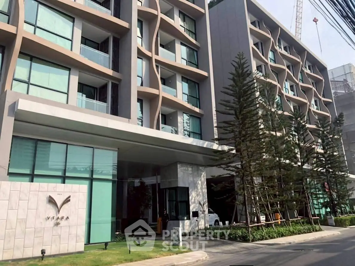 Modern apartment building with unique architectural design and lush landscaping.