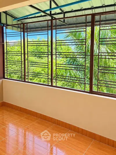 Spacious balcony with lush green view and tiled flooring