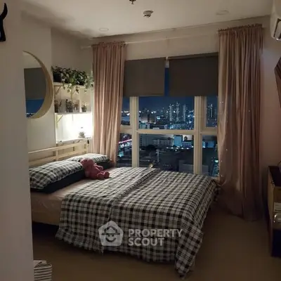 Cozy bedroom with city view, featuring stylish decor and large windows for natural light.