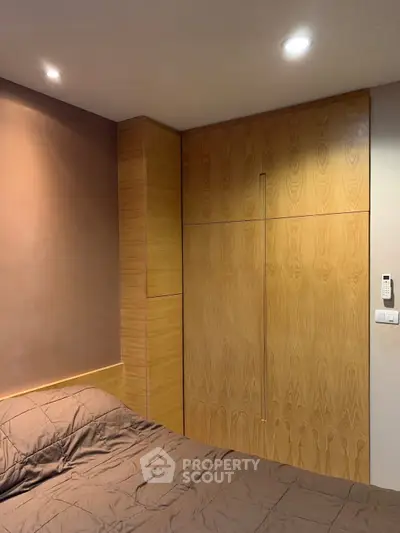 Cozy bedroom with built-in wooden wardrobe and soft lighting