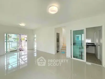 Spacious modern living room with glossy tile flooring and ample natural light