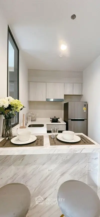 Modern kitchen with marble breakfast bar and stainless steel appliances