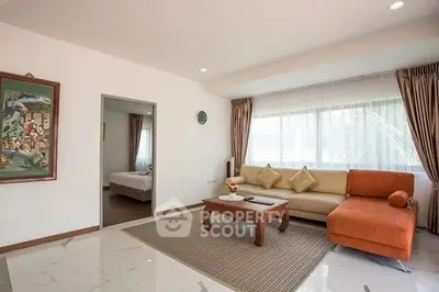 Spacious living room with modern decor and large windows for natural light