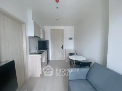 Modern minimalist studio apartment with compact kitchen and cozy living area.