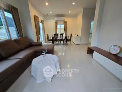 Spacious living room with modern furniture and dining area, perfect for family gatherings.