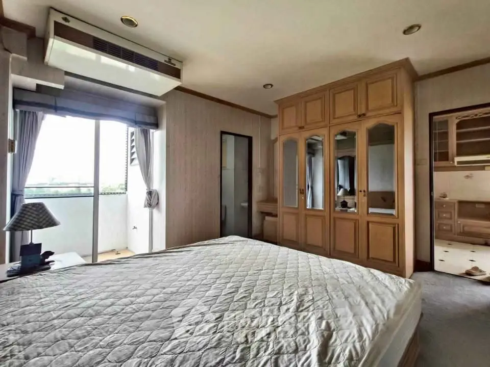 Spacious bedroom with balcony access and built-in wardrobe in modern apartment.