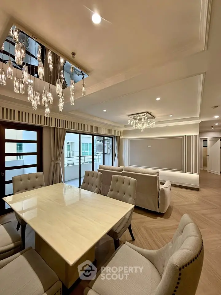 Luxurious living room with elegant chandelier and spacious dining area in modern apartment.