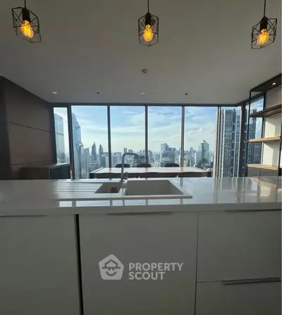Luxurious modern kitchen with stunning city skyline view and elegant lighting fixtures.