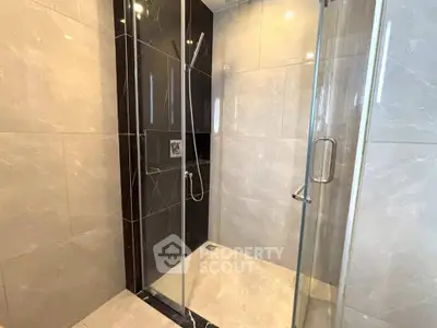 Luxurious modern bathroom with sleek glass shower enclosure and elegant tile design.