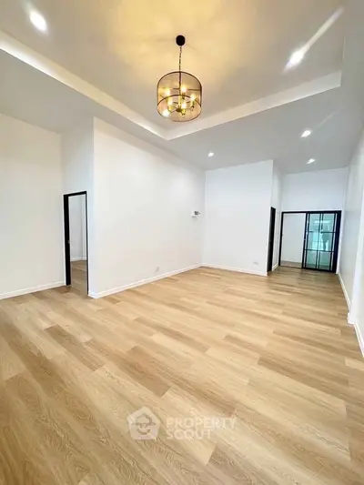 Spacious modern living room with elegant lighting and wood flooring