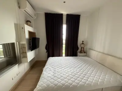Cozy bedroom with modern decor, featuring a wall-mounted TV and large window with dark curtains.