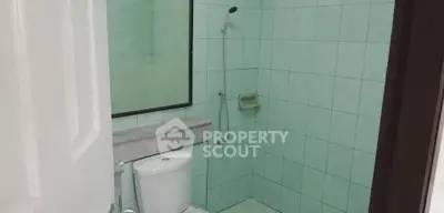 Modern bathroom with shower and toilet in a tiled setting
