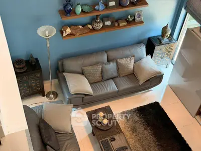 Stylish living room with modern gray sofas, decorative shelves, and elegant decor accents.
