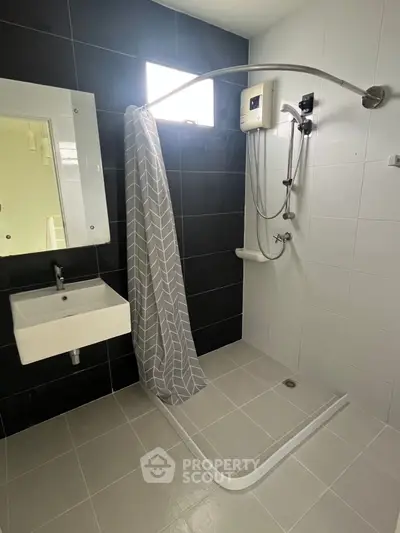 Modern bathroom with sleek shower and stylish black and white tiles