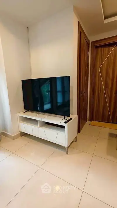 Modern living room with sleek TV stand and flat-screen TV, showcasing elegant interior design.