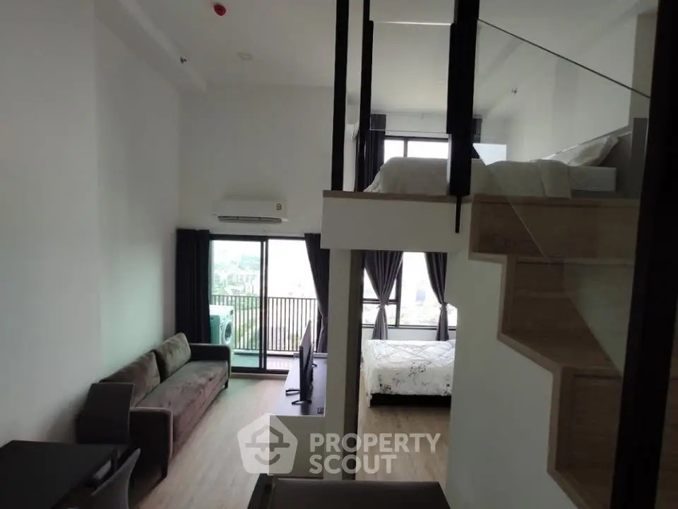 Modern loft apartment with mezzanine bedroom and spacious living area featuring large windows and balcony.